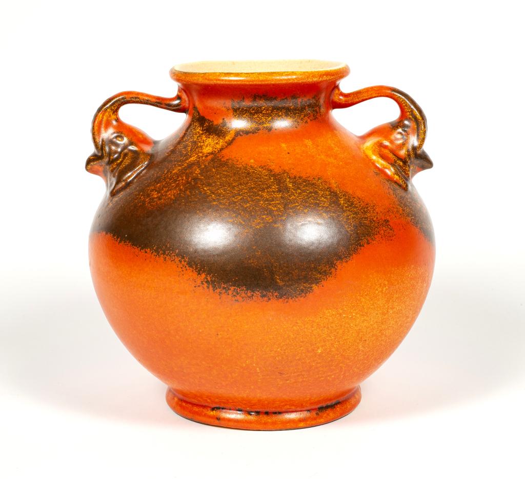 Red Wing Burnt Orange Elephant Vase: Item/Description: Rare, burnt orange two handled jug with carved elephant heads. Whimsical design; their elevated trunks (a sign of good luck) form the handles. Incised on base: 215. Material: Ceramic