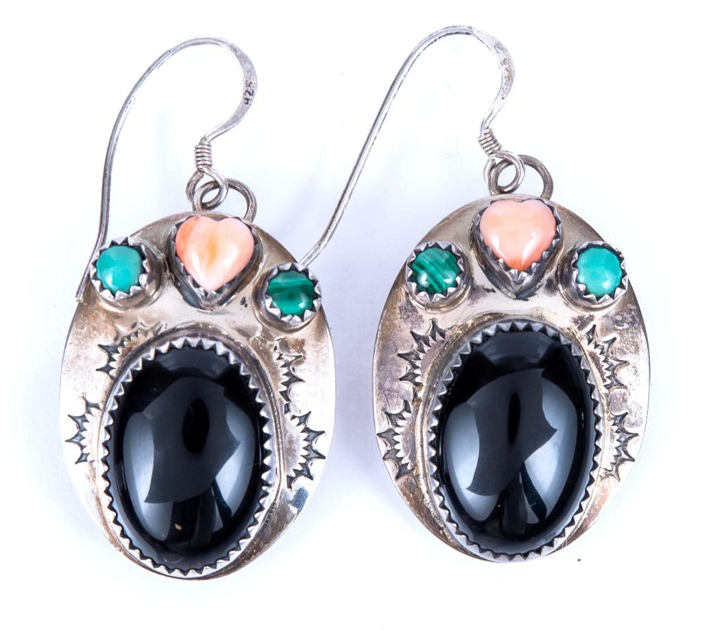 Sterling Navajo Concho D.H. Pierced Earrings: Item/Description: Signed Native American Concho Sterling Silver earrings fashioned as oval discs. Center polished oval onyx accented by turquoise and coral in saw tooth settings. Rattle snake jaw engr