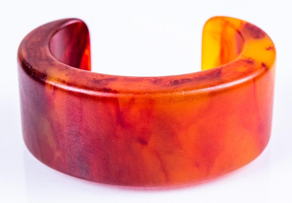 Modernist Carnelian Colored Resin Cuff: Item/Description: Mid-Century cuff in marbleized carnelian resin. Chunky and modernist. Rigid, will fit a small wrist. Unmarked. Material: Resin. Dimensions: 7"L x Width 1 1/4" x 1 3/8" opening. Condi