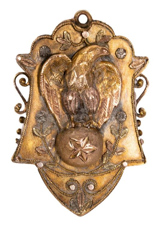 Victorian Gold-Filled Etruscan Style Locket: Item/Description: Unusual Victorian era gold filled locket. Shield shape. Front decorated in Etruscan motif. Raised eagle phoenix bird standing on a ball, feathers outstretched. Hinged compartment on 