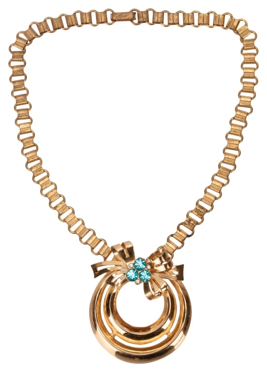 Signed Coro Bow Pendant Book Chain Necklace: Item/Description: Rare signed Coro Adolph Katz book chain choker. Retro era necklace fashioned in gold tone metal features a stylized wreath bow design with blue and clear crystal rhinestone accents.