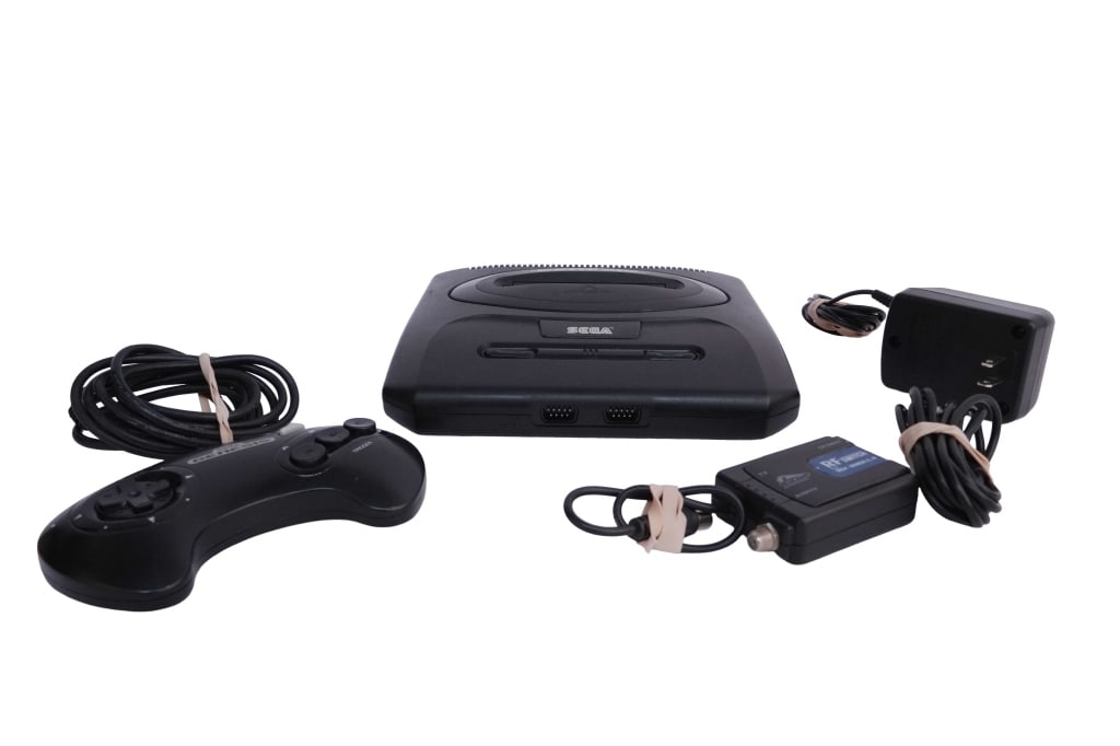 Sega Genesis Model 2 Home Video Game Console Set: Item/Description: Sega Genesis console, Model 2 (MK-1631), released in 1993, 16-bit home video game system with top-loading cartridge slot, square push-button power switch, and centered controller por