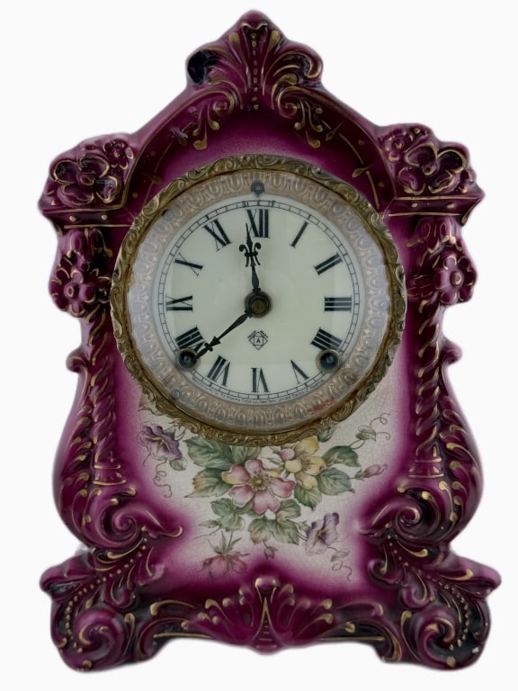 Antique Ansonia Royal Bonn Porcelain Mantel Clock: Item/Description: Late19th-century American-German collaboration featuring a fine Royal Bonn German porcelain case in vibrant magenta and white glaze, adorned with hand-painted floral vignettes and el