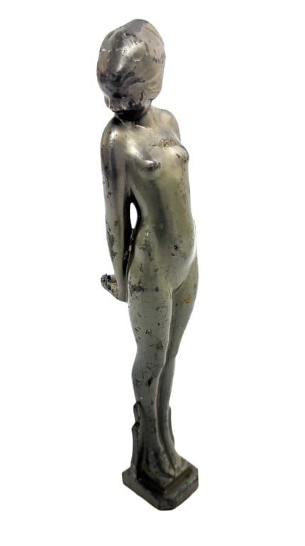 Art Deco Female Figural Automobile Hood Ornament: Item/Description: Machine Age automobile figural car mascot / hood ornament. Vintage figure portrays a slender, stylized Art Deco nude woman standing elegantly with her hands clasped tightly behind he