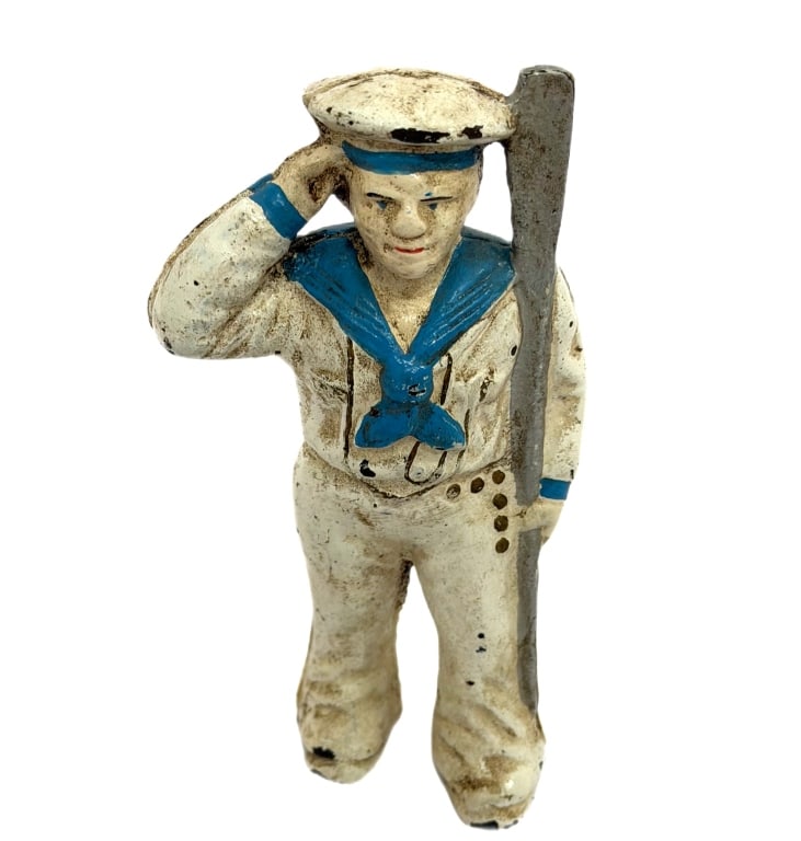 Antique Hubley Cast Iron Navy Sailor Coin Bank: Item/Description: Early 20th-century still bank cast in the patriotic form of a World War I-era U.S. Navy sailor in a traditional white and blue uniform, executing a formal hand salute while leaning a