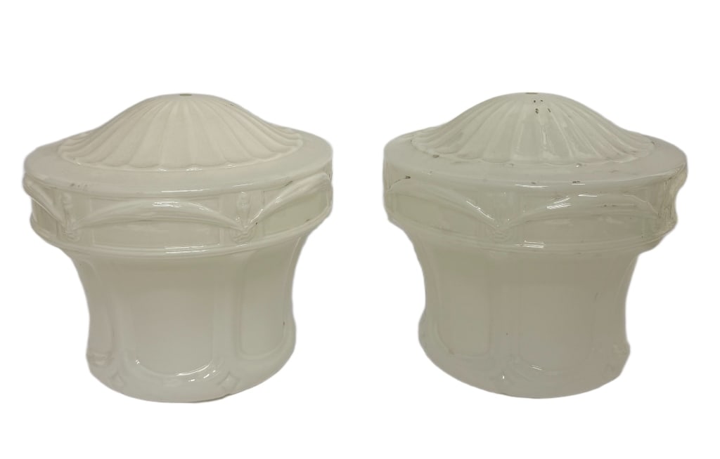 Pair of Art Deco Milk Glass Light Shades: Item/Description: Matching pair of vintage milk glass light shades featuring ribbed domed tops and paneled bases with geometric detailing. Each shade includes a central mounting hole and a glossy opal