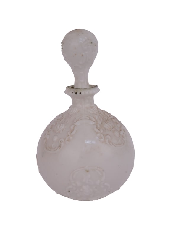 Victorian Milk Glass Barber Bottle: Item/Description: Late Victorian milk glass barber bottle with stopper featuring embossed floral and scroll design. Historically used in barber shops for tonics or as decorative boudoir vanity bottles