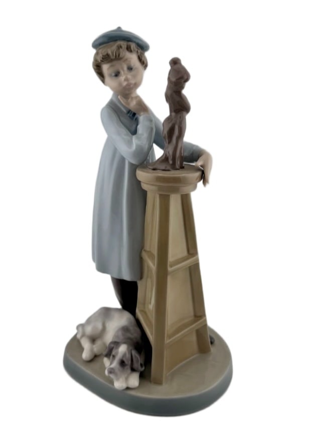 Lladro "Little Sculptor" Figurine: Item/Description: Lladro fine porcelain figurine titled "Little Sculptor" (Model No. 5358). Sculpted by artist Antonio Ramos. Issued in 1986, retired in 1989. Figurine features a thoughtful young boy