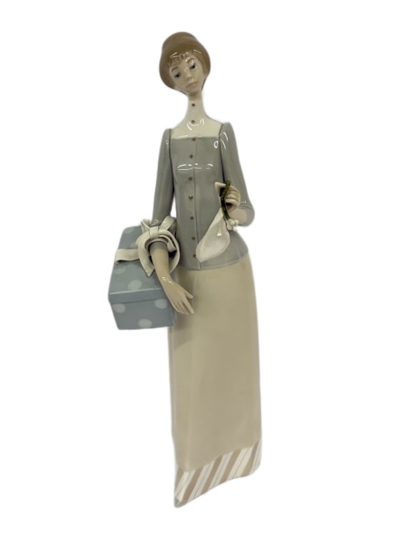 Lladro "The Dressmaker" Porcelain Figurine: Item/Description: Vintage Lladro "The Dressmaker" glazed porcelain figurine (Model No. 4700). Sculpted by noted master artist Vicente Martinez. Issued in 1970, retired in 1993. Figurine depicts an ele