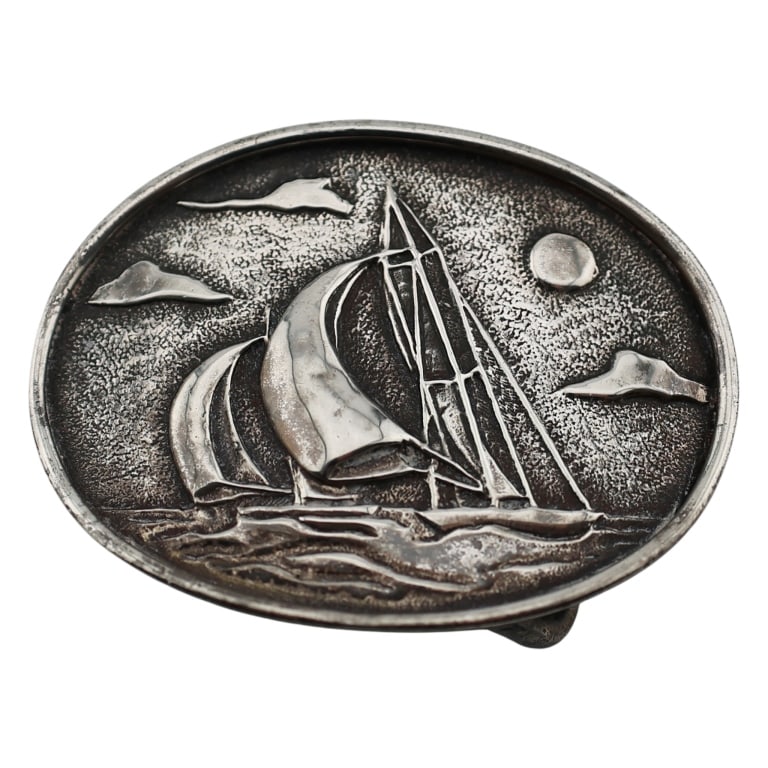 Cartier Sterling Yacht Sailing Belt Buckle: Item/Description: Signed belt buckle by luxury design house, Cartier. Unique in design and form and forged it is forged in sterling silver into a curved oval. Embossed maritime themed relief of