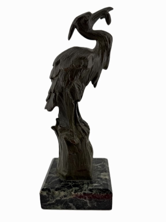 Patinated French Animalier Bronze Heron Sculpture: Item/Description: Decorative 20th-century French Animalier wildlife sculpture depicting a wading bird with a fresh catch. Mounted to a polished, variegated black and green marble display base. Unknown