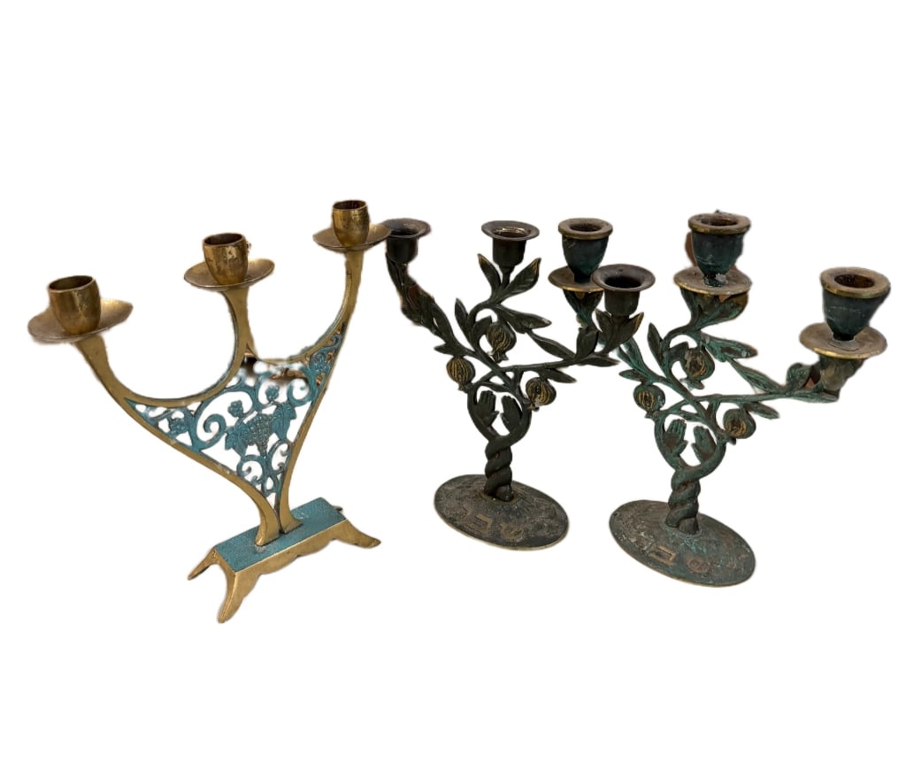 Israeli MCM Brass Shabbat Candleholders: Item/Description: A collection of three vintage Israeli Judaica candelabras, circa mid-20th century. Crafted from cast brass, featuring two matching three-light branch candelabras with a twisted trunk