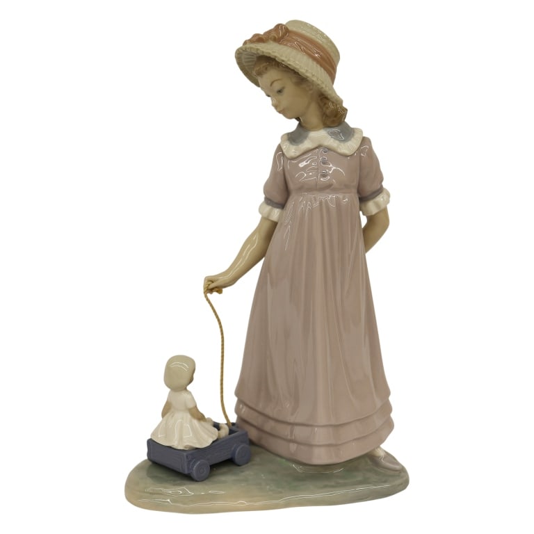 Lladro Child "Pulling Doll's Carriage" Figurine: Item/Description: Lladro "Pulling Dolls Carriage" (#5044) porcelain figurine, designed by Vicente Martinez. Issued in 1980 and retired in 1998. Figurine depicts a young girl in a light lavender dress 