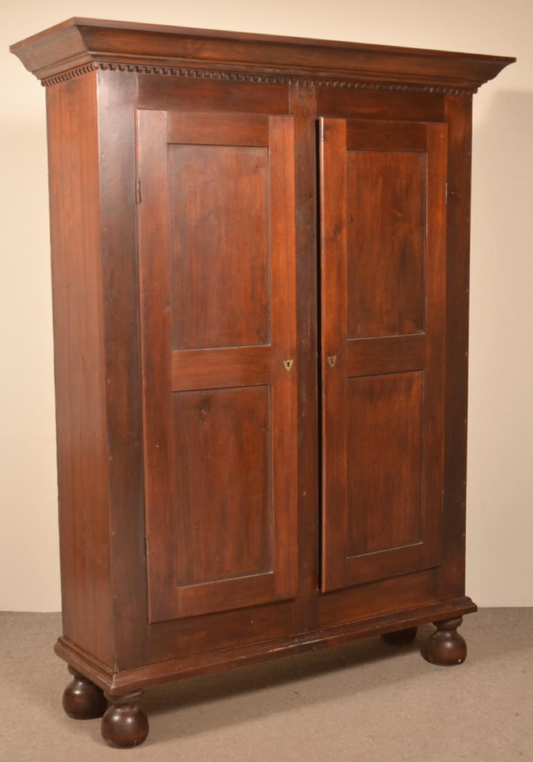 American Walnut Kas.: American Walnut Kas. Ogee and dentil molded cornice, paneled doors and turned feet. 83"h. s 62"w. x 20-1/2"d. Condition: Good, refinished and cornice is a replacement.