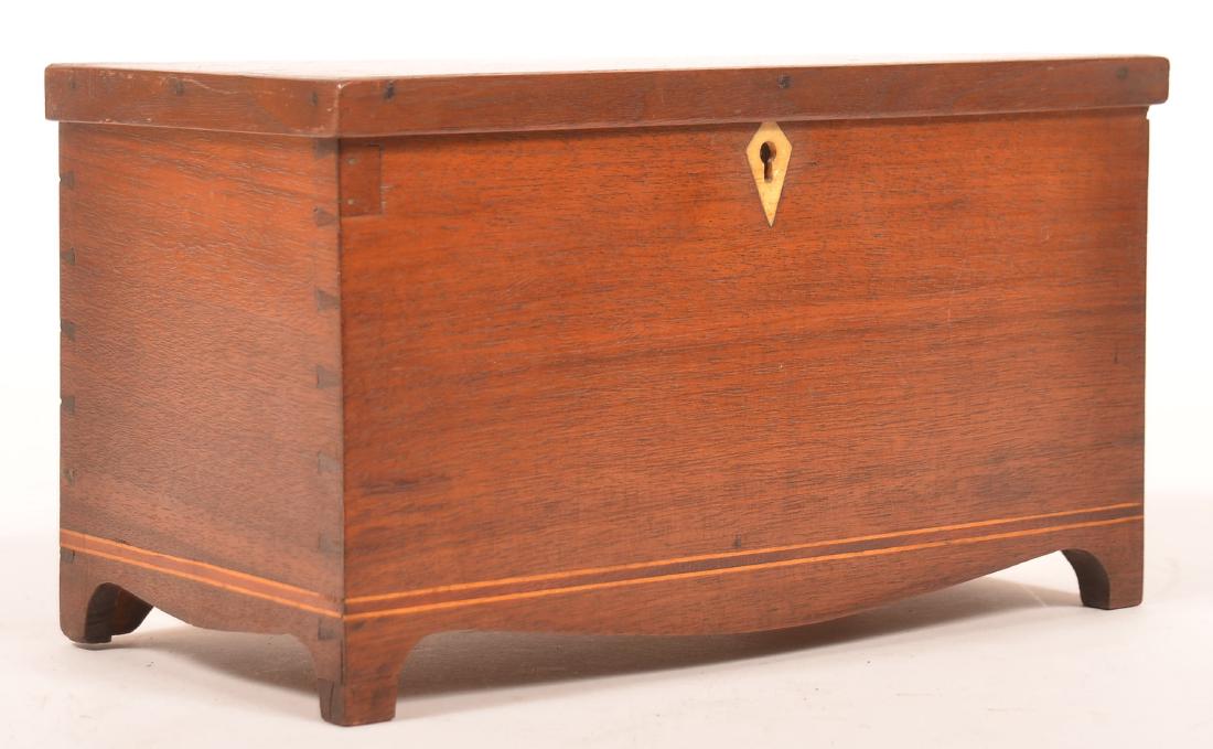 PA Hepplewhite Mahg. Miniature Blanket Chest.: Pennsylvania Hepplewhite Mahogany Miniature Blanket Chest. Molded hinged lid, interior till, dovetailed case with diamond shaped bone inlaid key escutcheon, banded inlay and bowed skirt with cut-out f