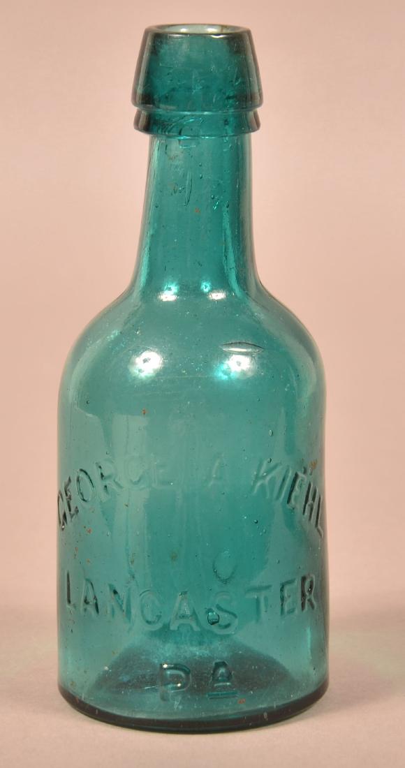 George A. Kiehl Aqua Squat Brewery Bottle.: George A. Kiehl, Lancaster, PA Aqua Squat Brewery Bottle. Double taper top with embossed lettering and smooth concave bottom. 6-1/2"h. Condition: Good.