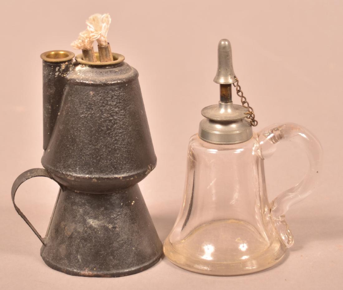 Two 19th Century Lighting Devices.: Two 19th Century Lighting Devices. Tin petticoat lamp, 4-3/4"h. and a colorless glass bell font whale oil lamp, with pewter hardware, 4-3/4"h. Condition: Good, petticoat has with rust and pitting.