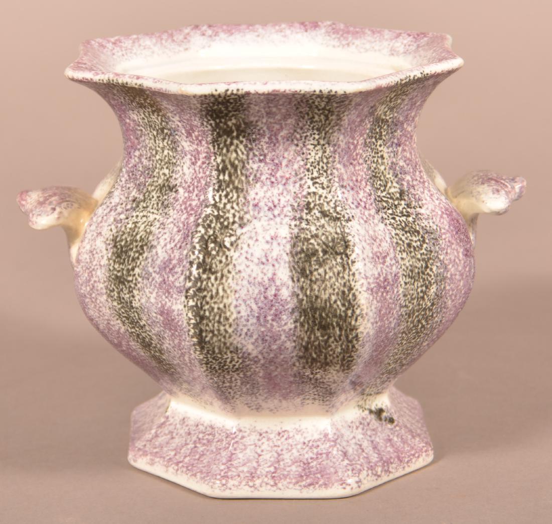 Purple and Black Rainbow Spatter Sugar Bowl.: Purple and Black Rainbow Spatter Paneled Ironstone China Sugar Bowl. Foliate handles and footed base. 5-1/2"h. Condition: Very good with glazing pop on underside of base. No lid.