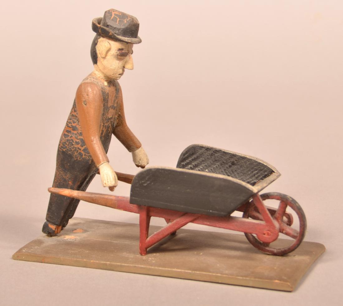 Folk Art Carving of a Man with Wheel Barrow. (1 of 3)