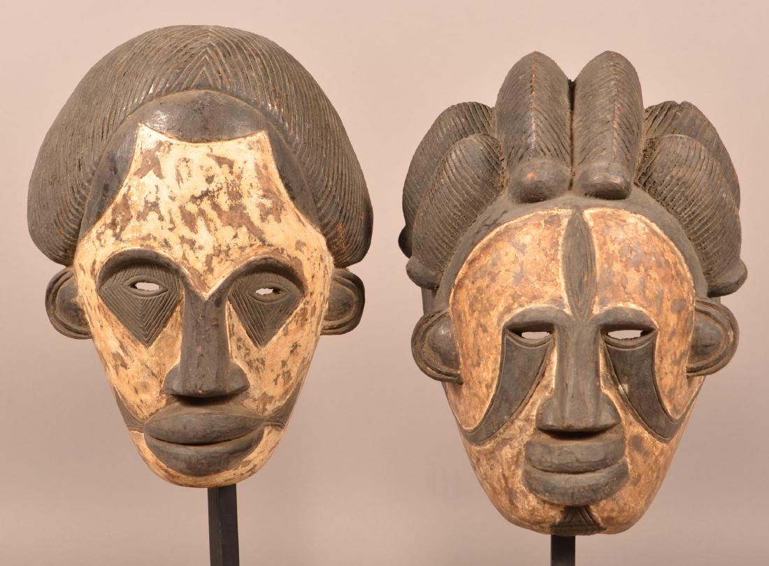 Two Antique/Vintage African Carved Wood Tribal Masks.: Two Antique/Vintage African Carved Wood Tribal Masks. Painted white. Tallest measures 15"h. Condition: Good with wear.