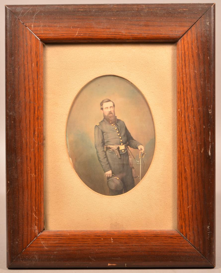 Hand Colored Photograph of a Civil War Officer. Having: Hand Colored Photograph of a Civil War Officer. Having a holstered revolver on his belt and resting his hand on a cavalry sword. Handwriting on verso identifies him as William Mann, 1st Lt., Co. C, 1s