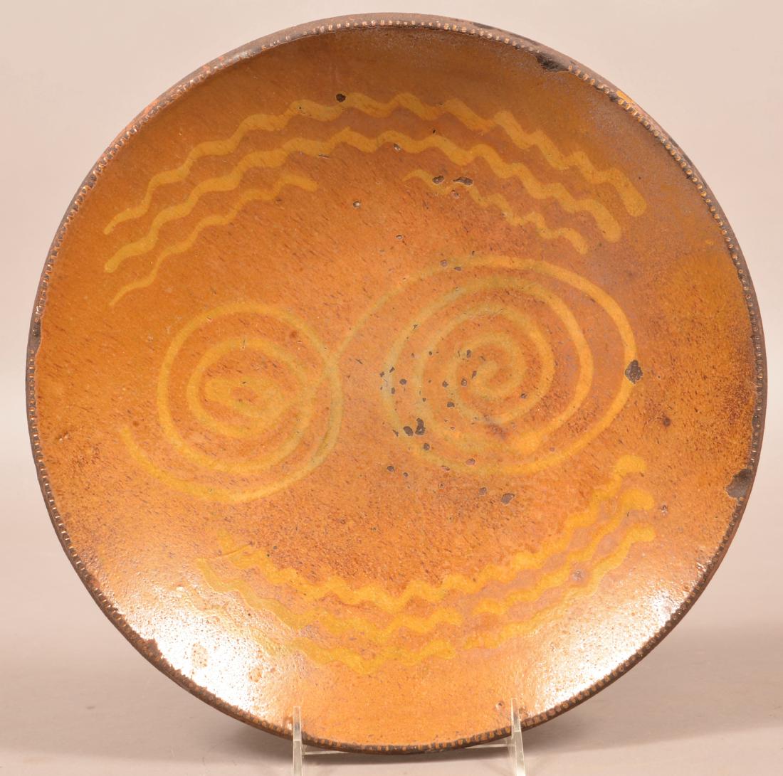 Pennsylvania 19th Century Redware Charger.: Pennsylvania 19th Century Redware Charger. Yellow slip decoration with coggle wheel edge. 12-1/2" diam. Condition: Good with edge chips and use wear.