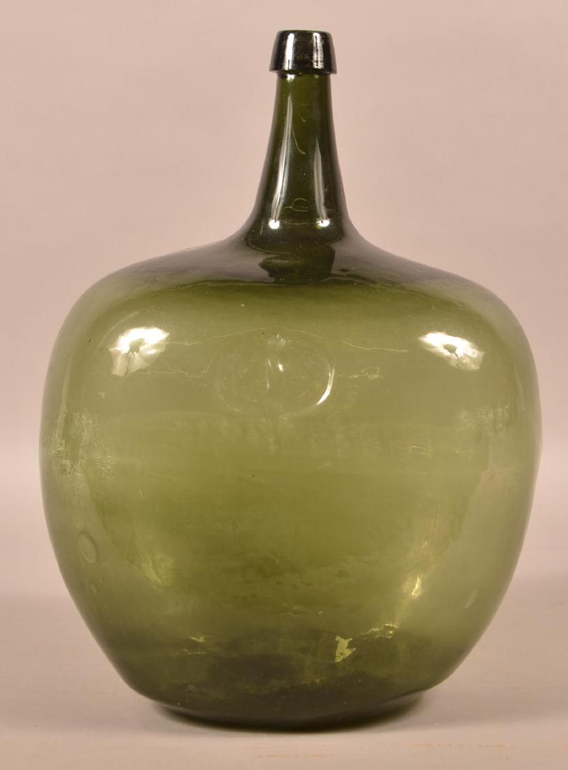 Olive Green Blown Glass Carboy Bottle.: Olive Green Blown Glass Carboy Bottle. Applied collar lip, conical neck , ovoid body and concave base with pontil mark. 20" high. Condition: Good with wear.