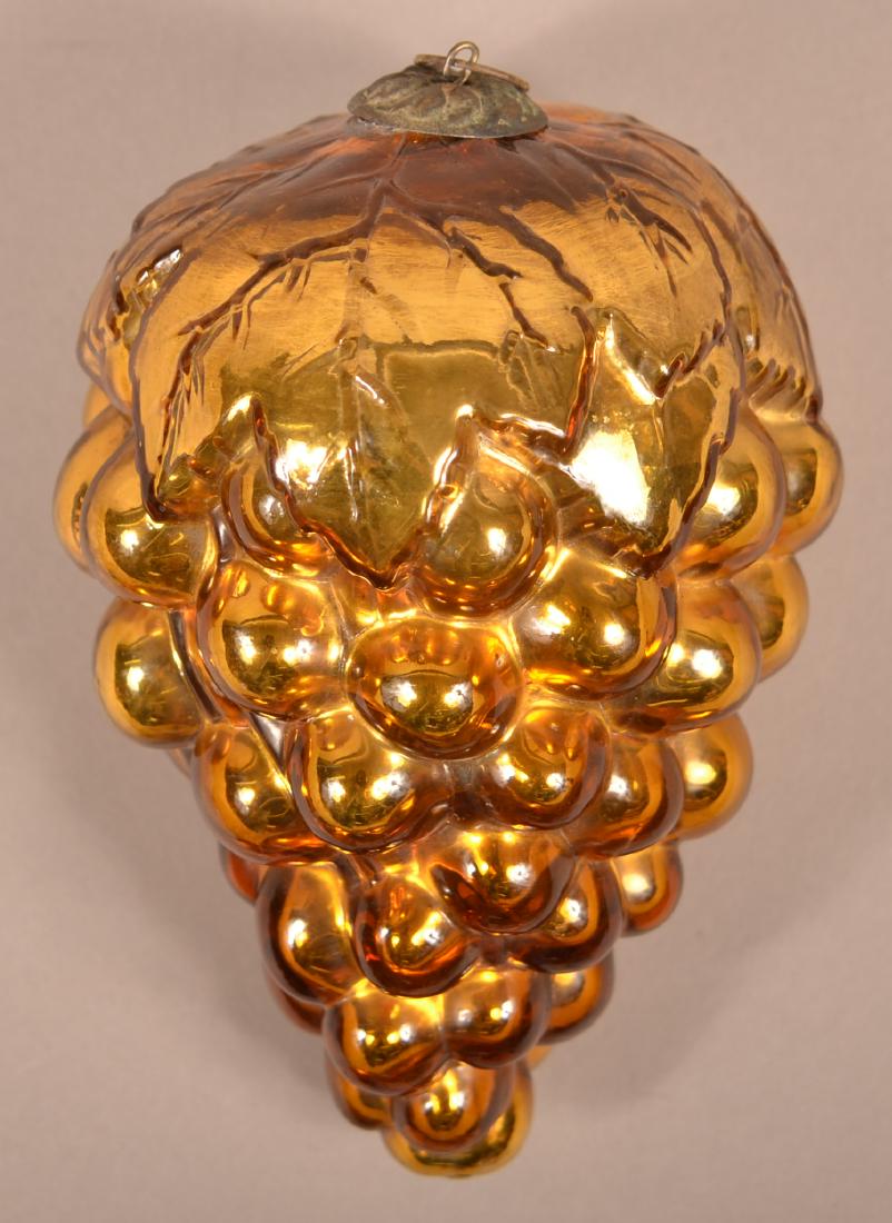 French Amber Glass Oval Leaf Grapes Kugel.: Antique French Amber Glass Oval Leaf Cluster of Grapes Kugel. Embossed "Depose" on top. (French registry mark). Baroque cap. Pictured in "Kugels: An Antique Christmas Obsession" by Joseph Krisky. 6"l.