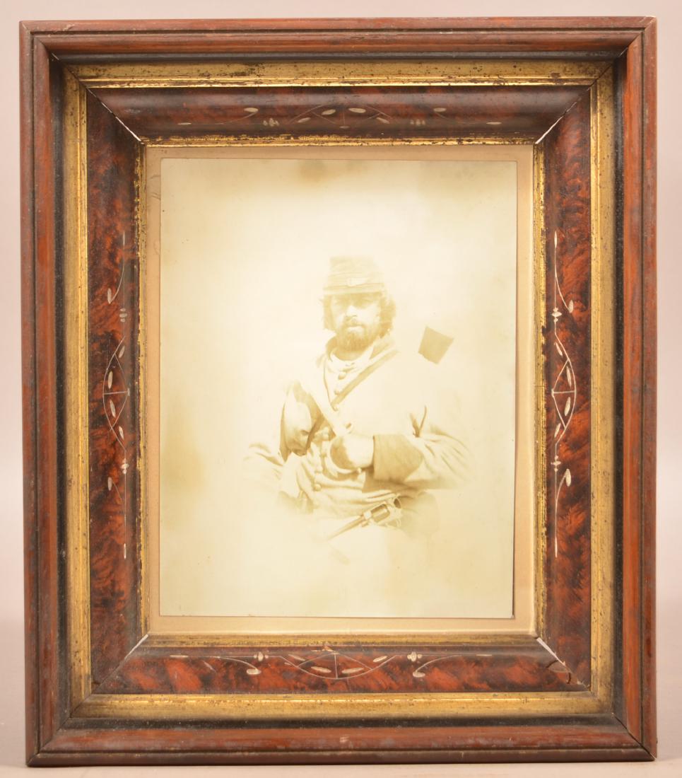 Carde' De Vista of a Confederate Soldier.: Carde' De Vista of a Confederate Soldier. Seated pose in uniform with a revolver in his belt and a carbine on his shoulder. In a walnut molded frame, 14-1/2" x 12-1/4" overall. Condition: Good with UV