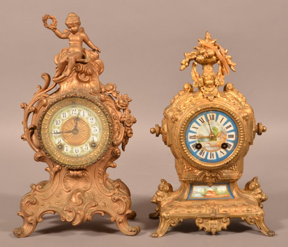 Two Cast Metal Cartouche Shelf Clocks.: Two Cast Metal Cartouche Shelf Clocks. Tallest measures 12-3/4"h. Condition: Good, one is missing the pendulum, the othe is missing crystal, pendulum and key.