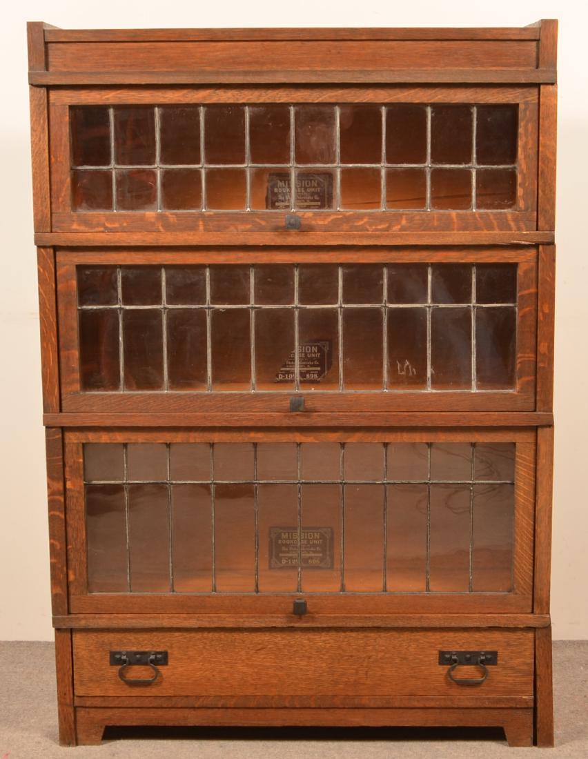 Globe-Wernieke Mission Oak Stacking Bookcase.: Globe-Wernieke Mission Oak Three Sectional Stacking Bookcase. Three leaded glass door sections with a full width lower drawer. 50-1/4"h. x 34-3/4"w. x 11-1/4"d. Condition: Good with minor wear.