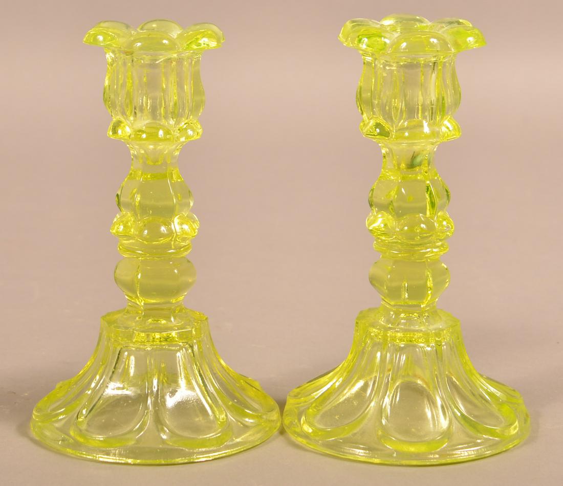 Pair of Vaseline Flint Sandwich Glass Candlesticks.: Pair of Vaseline Flint Sandwich Glass Candlesticks. Six petal sockets with foliate extensions and loop flared base. 7"h. Condition: Good, One with small crack on socket.