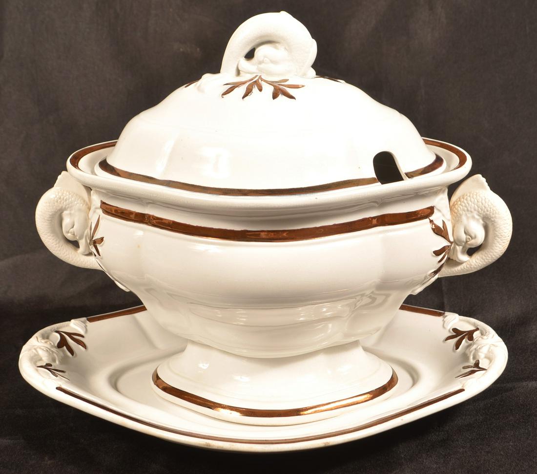 White Ironstone China Soup Tureen by J. Clementson.: White Ironstone China Soup Tureen by J. Clementson. Dolphin handles and finial with copper lustre highlights. 11-1/2"h. x 14-1/2"w. Undertray measures 12" x 15-1/4". Condition: Very good.