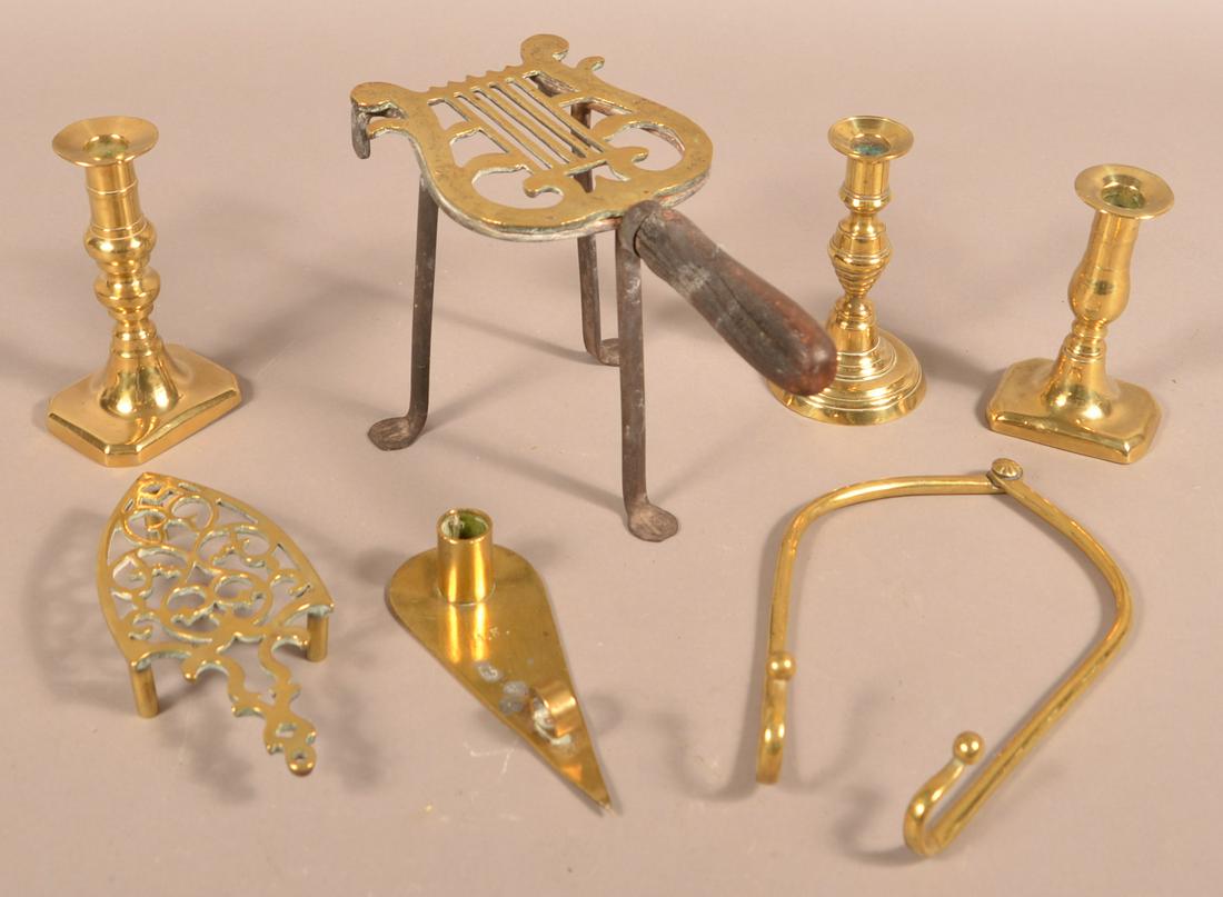 Lot of Antique Brass Items.: Lot of Antique Brass Items. Including two trivets, various candlesticks, and a pot lifter. Larger trivet measures 7"h. Condition: Good with wear.