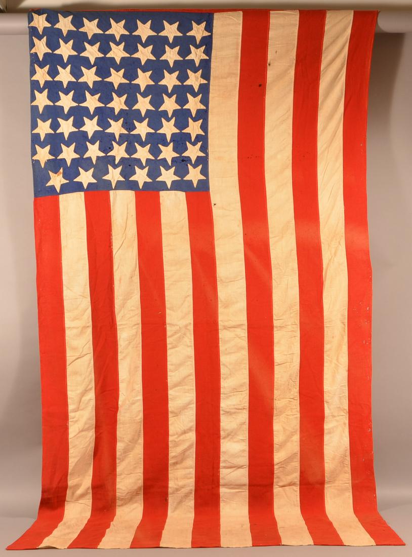 American 48 Star Hand-Stitched Flag.: American 48 Star Hand-Stitched Flag. Cotton, wool and felt with applique stars. 51" x 96". Condition: Good with some holes and stains.
