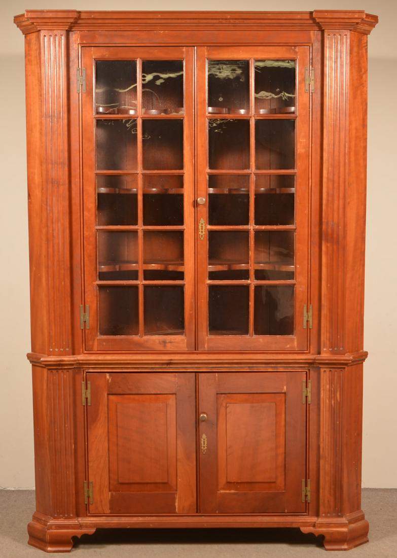 Chippendale Style Cherry Architectural Corner Cupboard.: Vintage Chippendale-Style Cherry Architectural Corner Cupboard. Single part with bold stepped molded cornice above two glazed doors and reeded stiles, above two lower raised panel doors reeded stiles,