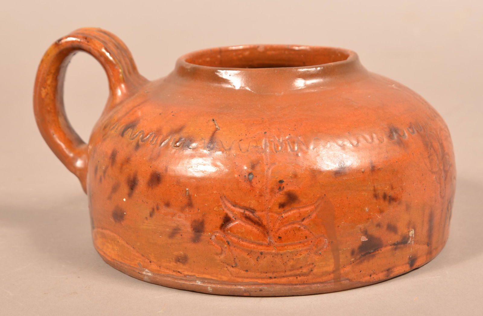 PA 19th Century Sgrafitto Decorated Redware Bean Pot.: Pennsylvania 19th Century Sgrafitto Decorated Redware Bean Pot. Squat form with Incised potted flowers and applied ribbed strap handle. 5"h. x 8" diam. Condition: Rim and shoulder repairs, missing lid