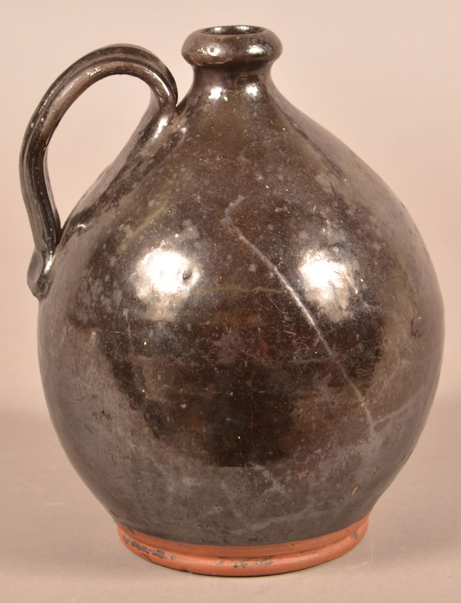 Chester Co., PA Manganese Glazed Redware Jug.: Chester County, PA 19th Century Manganese Glazed Redware Jug. Rounded rim, ovoid body and applied ribbed strap handle. 8"h. Condition: Good with wear.