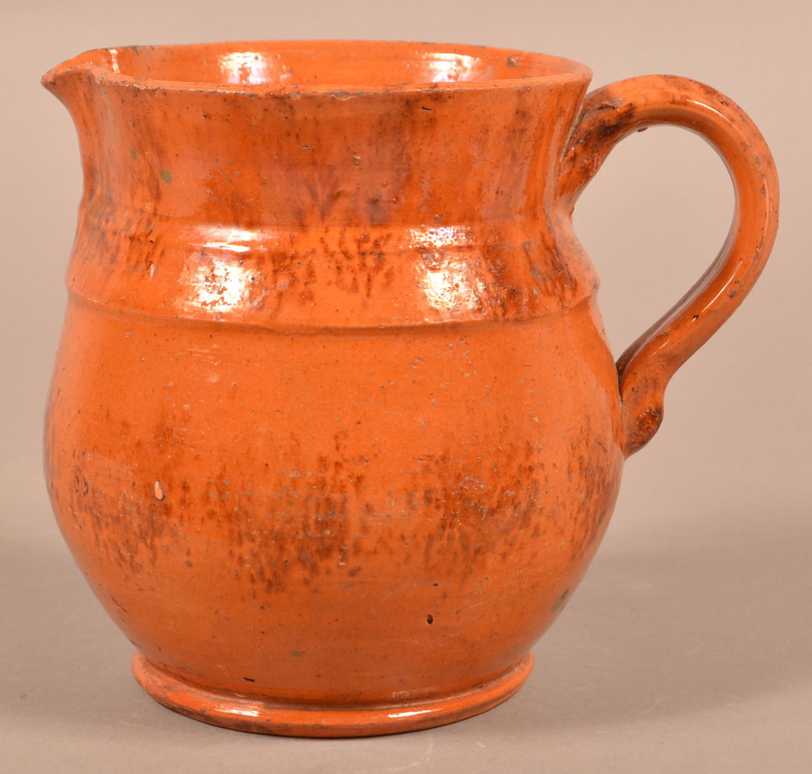 Antique Sponge Decorated Glazed Redware Pitcher.: Antique Sponge Decorated Glazed Redware Pitcher. Molded shoulder, bulbous body and applied ribbed strap handle. 6-1/2"h. Condition: Good with wear and glaze pop.