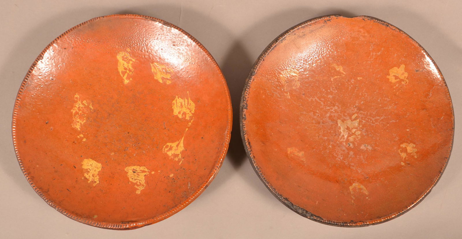 Two Pennsylvania 19th Century Redware Chargers.: Two Pennsylvania 19th Century Redware Chargers. Yellow slip decoration. 12" diam. Condition: Good with rim chips.
