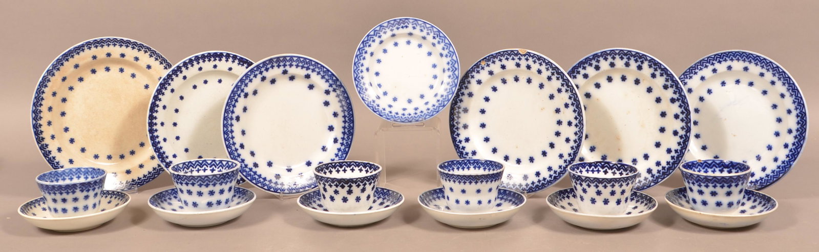 19 Pieces of Flow Blue Snowflake Ironstone China.: 19 Pieces of Flow Blue Snowflake Ironstone China. Seven various plates, six cups and saucers. Largest plate measures 9-3/4" diam. Condition: Good, one cup has a hairline, one plate has stains.