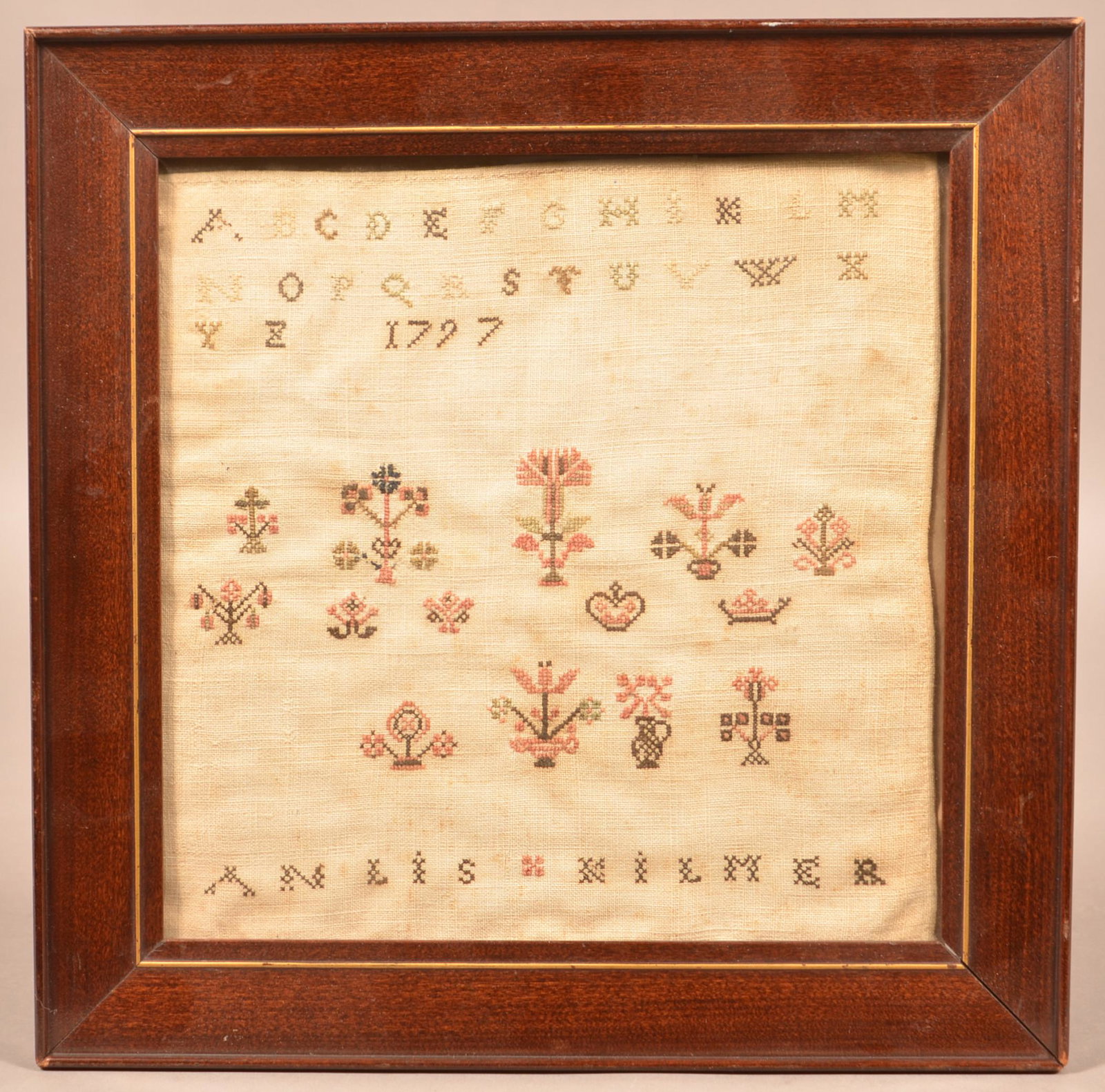 Pennsylvania Cross Stitch Alphabet Sampler Dated 1797.: Pennsylvania Cross Stitch Alphabet Sampler. "Anlis Kilmer 1797". Rowed type with potted flowers. In a later frame, 12" square overall. Condition: Good with foxing.