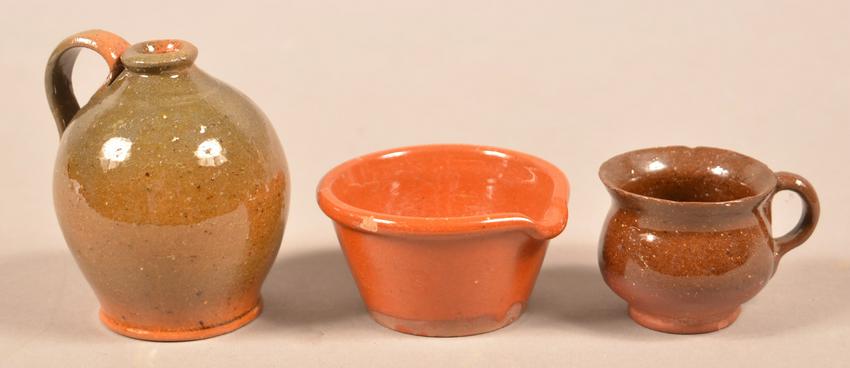 Three Pieces of Antique Miniature Glazed Redware.: Three Pieces of Antique Miniature Glazed Redware. Green/orange glazed jug, 3-1/2'h., brown glaze mug, 1-3/4"h. and an orange glaze milk bowl, 3" diam. Condition: Very good with a few tiny chips.