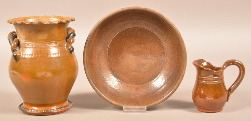 Three Pieces of Signed Stahl Redware.: Three Pieces of Signed Stahl Redware. 8" Vase dated 1936, 8-3/4" diam. bowl dated 1940 and 4-1/2" cream pitcher dated 1953. Condition: Good, vase has chips and glazing flaws.