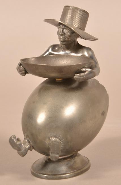 Quadruple Plate Black Americana Cigar Holder.: Quadruple Plate Black Americana Cigar Holder. Slave boy wearing a hat to hold matches, larger shell with his two feet protruding through to hold cigars, and he is holding a half shell for burnt matche