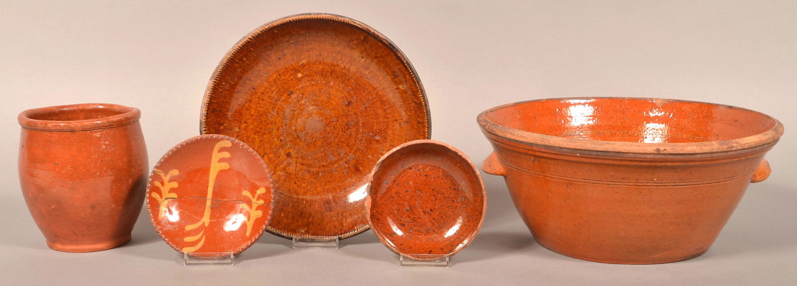 Lot of 19th Century Glazed Redware.: Lot of 19th Century Glazed Redware. Including bowls, plates and a crock. Milk bowl 13"diam. Condition: Fair with wear, chips and cracks.