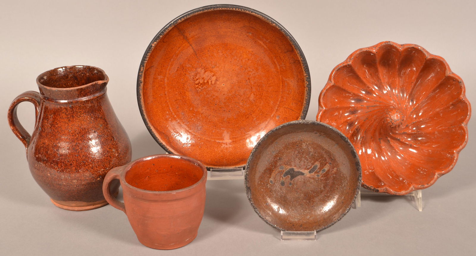 Lot of 19th Century Glazed Redware.: Lot of 19th Century Glazed Redware. Including plates, Turks mold, pitcher and an apple butter crock. Pitcher measures 8-1/4"h. Condition: Fair with wear, chips and cracks.