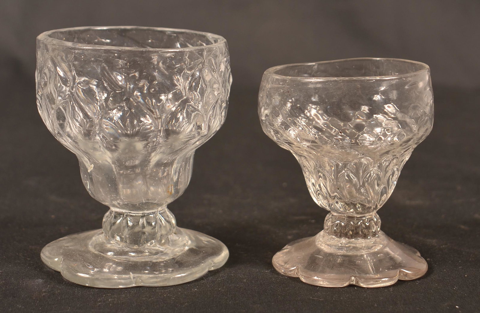 2 Stiegel Type Expanded Diamond Footed Master Salts.: Two Stiegel Type Expanded Diamond Footed Master Salts. Colorless glass with petal bases. Largest 3-1/4"h. Condition: Very good.