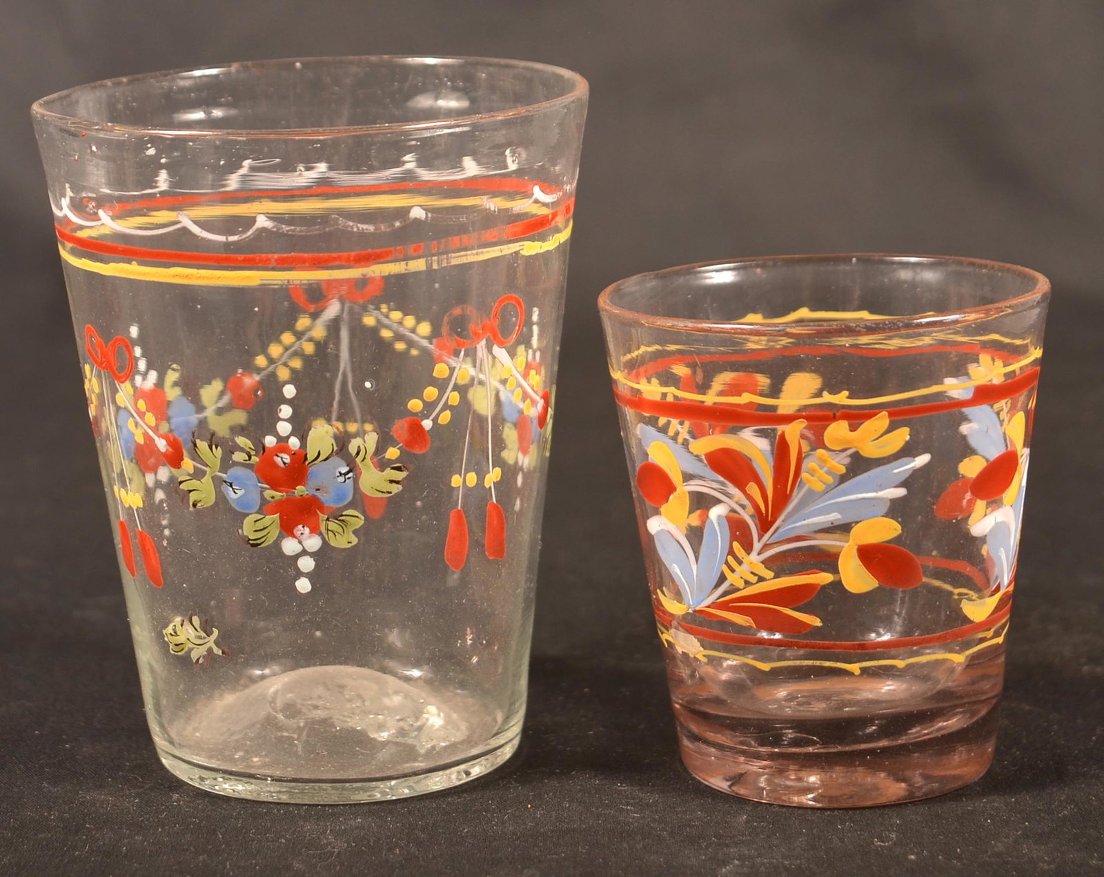 Two Stiegel Type Enamel Decorated Glass Tumblers.: Two Stiegel Type Polychrome Enamel Decorated Colorless Glass Tumblers. Tallest 4"h. Condition: Good with minor wear.