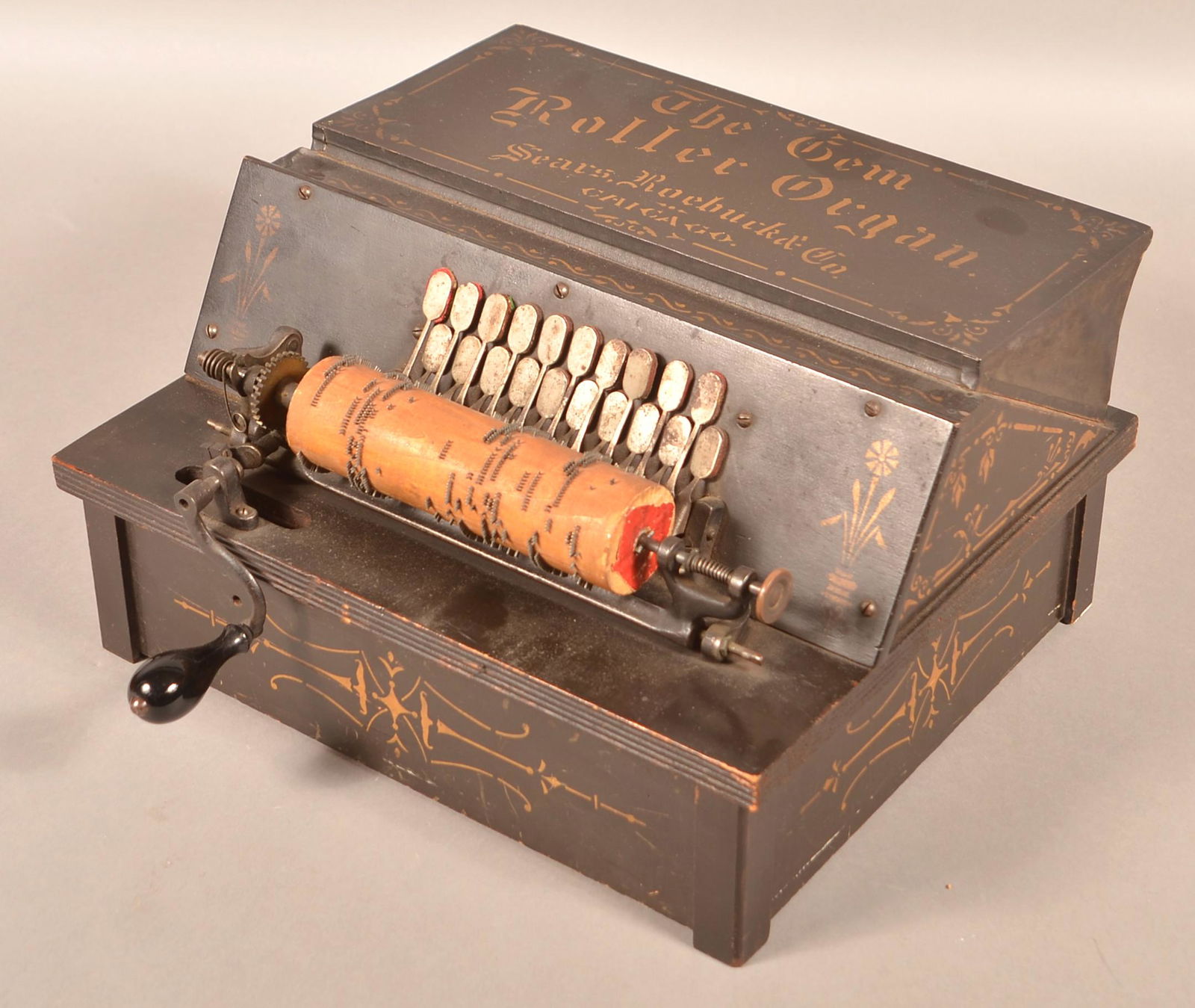 The Gem Roller Organ with 13 Rolls.: The Gem Roller Organ with 13 Rolls. Sears, Roebuck & Co., Chicago. Black ground with gold lettering and Eastlake style accents. 8"h. x 14-1/2"w. x 12"d. (not including crank). Condition: Good with min
